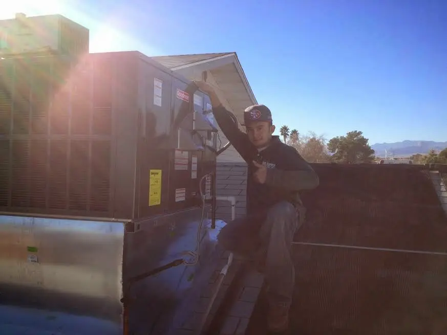 HVAC technician performing AC Tune-Up on a rooftop unit in Atwater